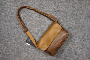 Close-up detail of retro brown leather shoulder bag with adjustable strap and tag.