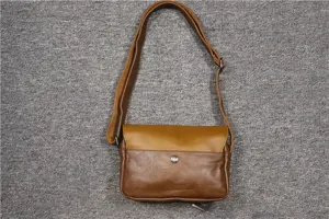 Brown leather messenger bag detail, vintage retro crossbody style with adjustable shoulder strap.