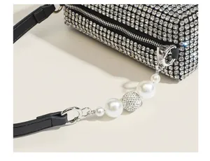 Rhinestone evening bag detail showing sparkling crystals and elegant pearl charm.