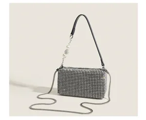 Exquisite rhinestone evening bag detail, sparkling crystals with chic chain and pearl strap.