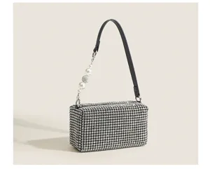 Rhinestone evening bag detail showing glittering crystal surface, black strap and pearl charm.