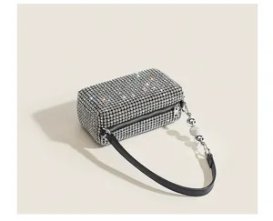 Detailed view of luxury rhinestone cylinder evening handbag with sparkling diamonds and black strap.