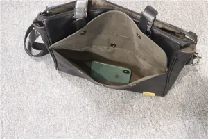 Black business men leather briefcase detail view with multi compartments and phone pocket.