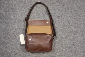 Brown vintage messenger bag detail showing flap closure and adjustable strap construction.