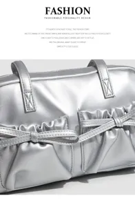 Silver metallic shoulder bag with double handles, chic front pockets and bow detail.