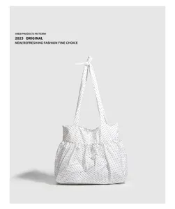 Primo piano che mostra la borsa tote in cotone a pois chic con grazioso manico a fiocco.