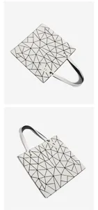 Détail en gros plan du sac cabas blanc à motif géométrique et panneaux triangulaires.