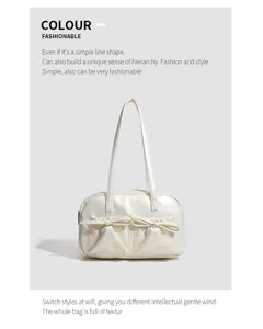 Detailed view of the white glossy shoulder bag, highlighting front bow pockets and dual straps.