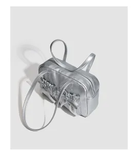 Silver metallic handbag detail, showing stylish ruffles and bow design for women.