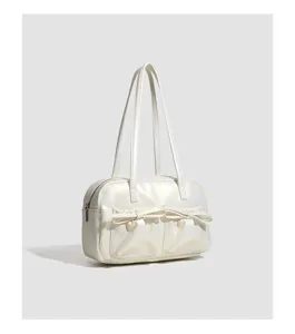 White shoulder bowling bag detail, sleek glossy leather with cute double bow front pockets.