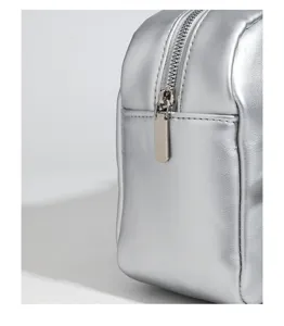 Silver metallic cosmetic pouch detail, premium glossy finish with secure zipper closure.