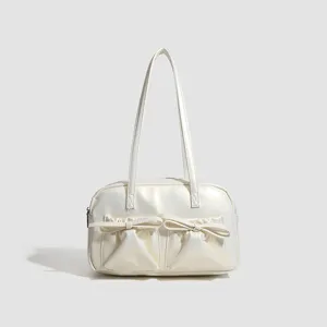 Chic white bowling shoulder bag for women, stylish underarm handbag with cute bow pockets.