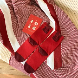 Red cotton mid-tube socks for women, festive Year of the Zodiac winter hosiery with fuzzy Chinese character details.