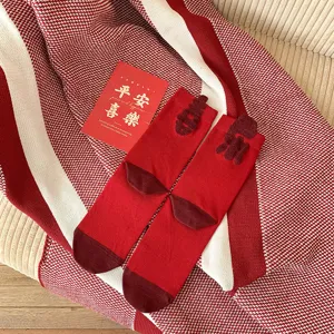 Detailed shot of festive red winter mid-tube socks featuring soft cotton fabric and cute flocking details.