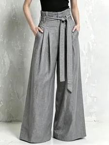 Detail shot of high-waisted grey wide-leg trousers featuring a paperbag waist and belt.
