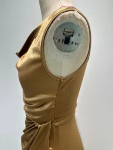 Golden metallic sleeveless dress detail showing draped bodice, elegant evening wear side view.