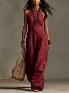 Detail view of a chic burgundy sleeveless halter linen jumpsuit with woven tote bag.