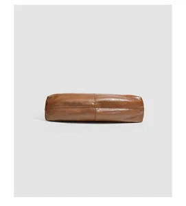 Detaillierte Bodenansicht einer stilvollen braunen Leder-Baguettetasche mit feinen Nähten.