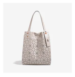 Close-up view of grey geometric lattice tote bag, showing unique triangular panel details.