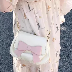 Sweet bow saddle bag for women, white leather crossbody bag with pink bow, stylish main view.