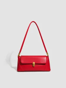 Red leather shoulder bag detail view, minimalist gold hardware chic baguette handbag.