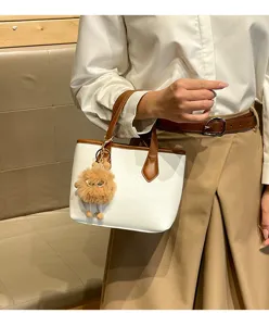 White lychee pattern commuter handbag with brown trim and cute plush charm for women daily use.