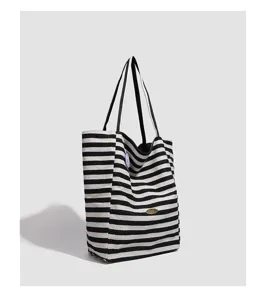 Detail view of the black and white striped canvas tote bag showcasing texture and stitching.