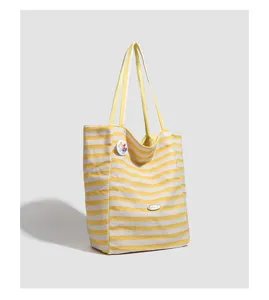 Yellow white striped canvas tote bag detail, casual large capacity shoulder bag design.
