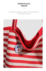 Close-up detail of red and white striped canvas tote bag, featuring a cute duck badge.