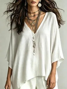 Detail view of a stylish white V-neck casual linen top featuring layered vintage metal necklaces.