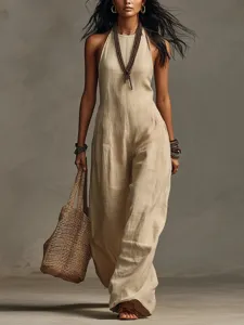 Women's chic halter linen blend jumpsuit with woven straw handbag fashion summer outfit.