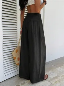 Detail view of black high waisted wide leg pants in casual resort style for women.