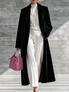 Detail view of women's black velvet long coat showcasing premium texture and lapel design.