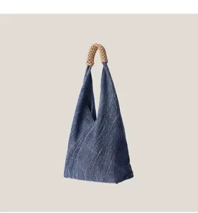 Vue détaillée du sac hobo élégant en jean avec poignée tressée unique et texture douce.