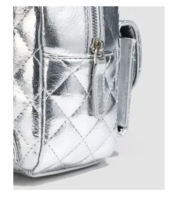 Detailed view of silver quilted backpack texture, zipper, and side pocket design.
