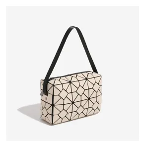 Geometric lattice handbag detail, featuring unique triangular panels and black strap handle.