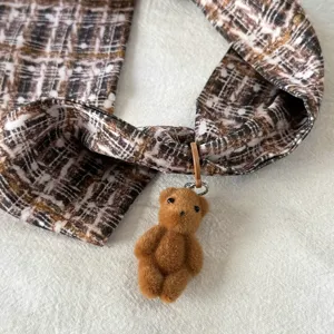 Detailed shot of Korean style chic patterned neck scarf with cute plush brown bear pendant charm.