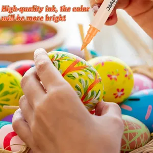Acrylic marker detail shot showing hand painting colorful easter eggs with vibrant orange tip.