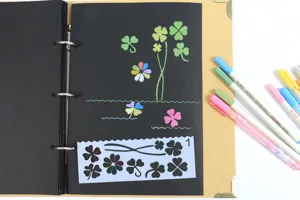 DIY zwart papier fotoalbum set met metallic pennen en klaverblad tekening sjablonen.