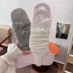 Detailed view of sweet Lolita lace stirrup leg warmers in grey and white colors.