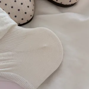 White knitted stirrup sock detail showing soft ribbed texture fabric close-up view.