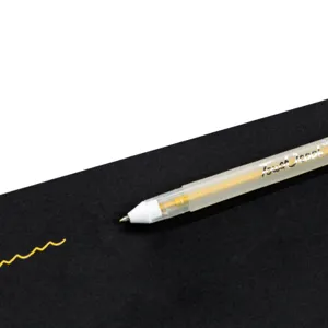 Close-up of the highlight gel pen with a bullet tip, writing gold ink on black paper smoothly.