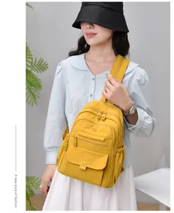 Detail view of yellow nylon backpack with multiple zipper pockets, stylish and convenient.