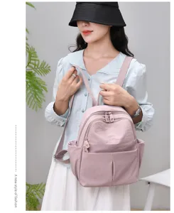 Stylish women's pink backpack, large capacity waterproof travel and casual school bag detail.
