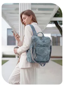 Details of the grey vintage distressed women backpack featuring ethnic strap and multi-pocket.