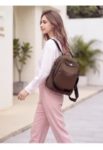 Outdoor lifestyle detail view of a stylish brown women backpack worn by a model on street.