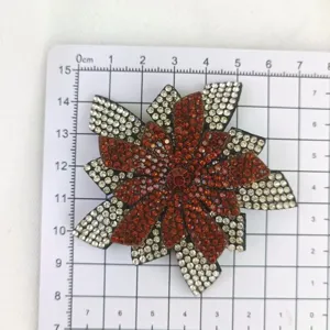 Rhinestone flower accessory detail showing sparkling red and clear crystals on grid.