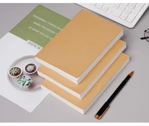 Gedetailleerd overzicht van dikke lege notitieboekjes van kraftpapier netjes op bureau gestapeld.
