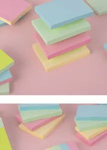 Dettaglio di note adesive colorate, blocchetti per appunti pastello quadrati impilati.