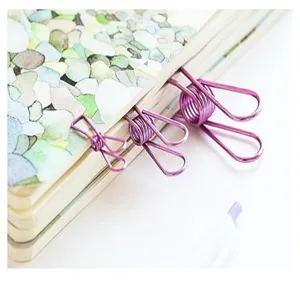 Primer plano de clips de metal morado para cuaderno, perfectos para la organización de oficinas.